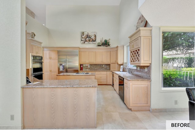 kitchen featuring a center island, backsplash, sink, appliances with stainless steel finishes, and a breakfast bar area