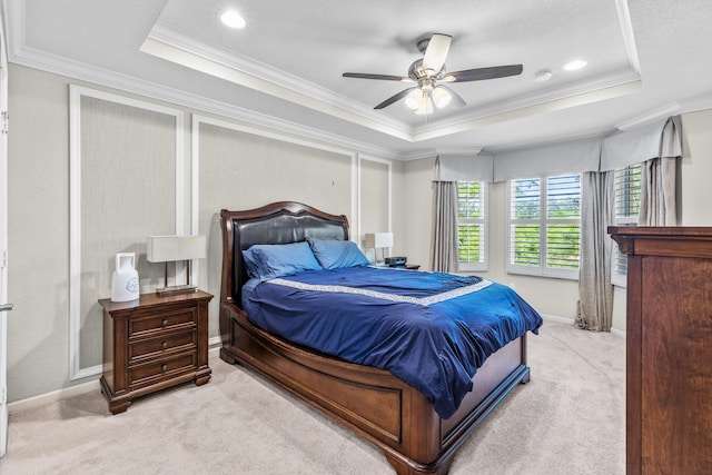 carpeted bedroom with crown molding, ceiling fan, and a raised ceiling