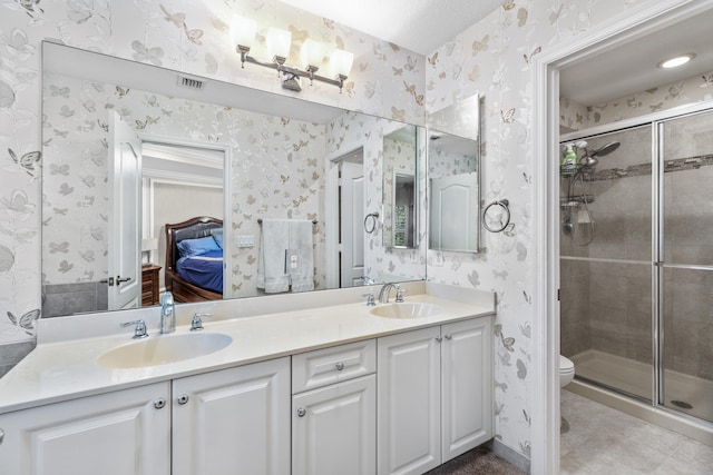 bathroom featuring toilet, vanity, tile patterned floors, and walk in shower