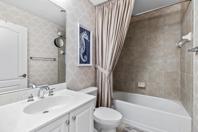 full bathroom featuring vanity, a textured ceiling, toilet, and shower / tub combo with curtain