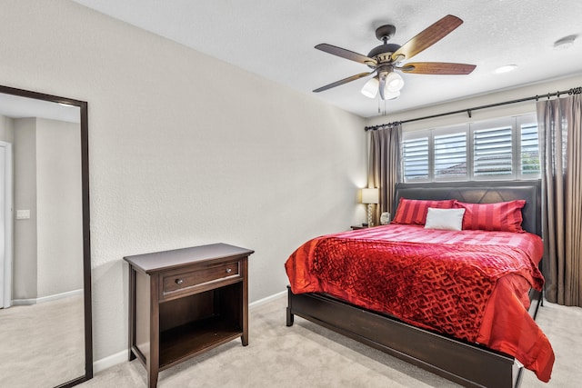 bedroom with a textured ceiling, light carpet, and ceiling fan