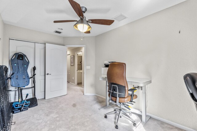 carpeted office space with ceiling fan