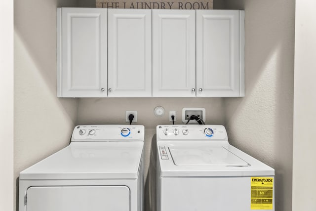 laundry room with washing machine and dryer and cabinets