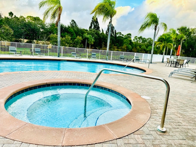 view of swimming pool featuring a patio and a hot tub