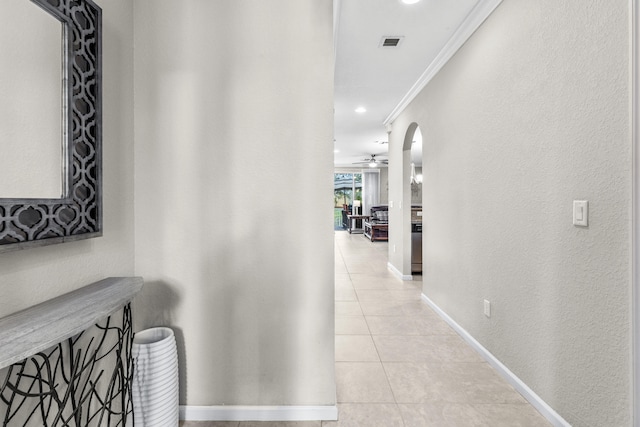 corridor with light tile patterned floors and crown molding