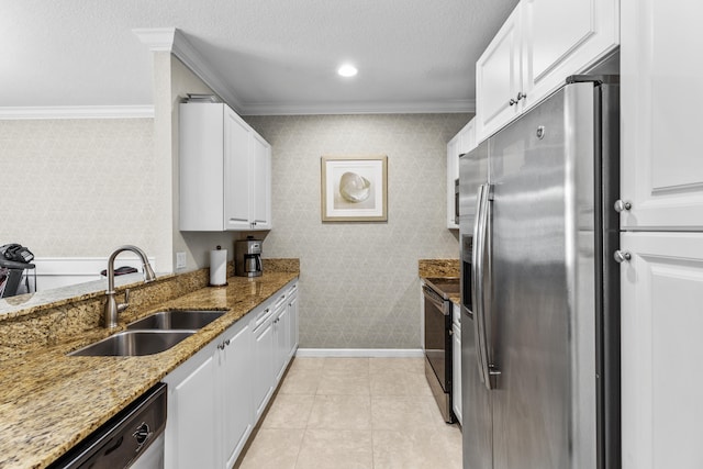 kitchen with light stone countertops, white cabinets, sink, and stainless steel appliances