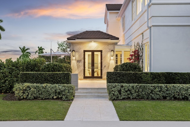 entrance to property with french doors and a yard