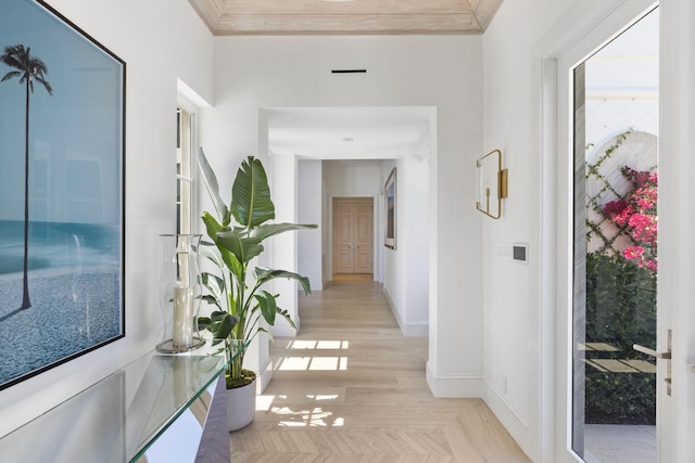 hallway featuring light wood-type flooring, baseboards, and ornamental molding