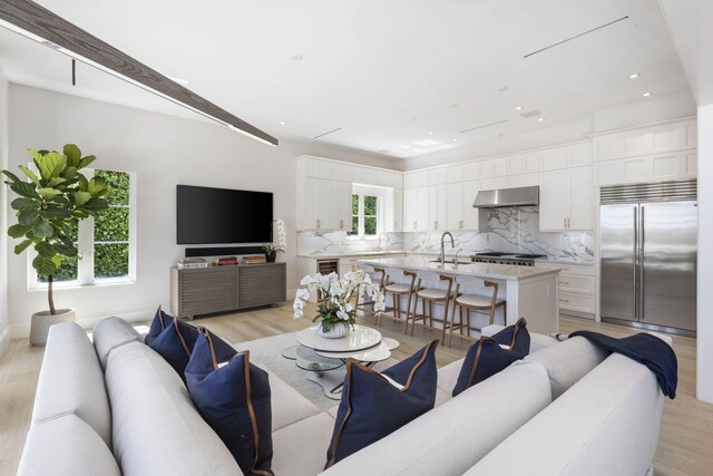 interior space featuring a chandelier, a raised ceiling, light wood finished floors, and stairs