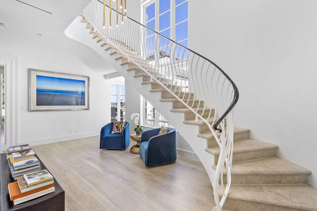 hall featuring recessed lighting, wood finished floors, an upstairs landing, and crown molding