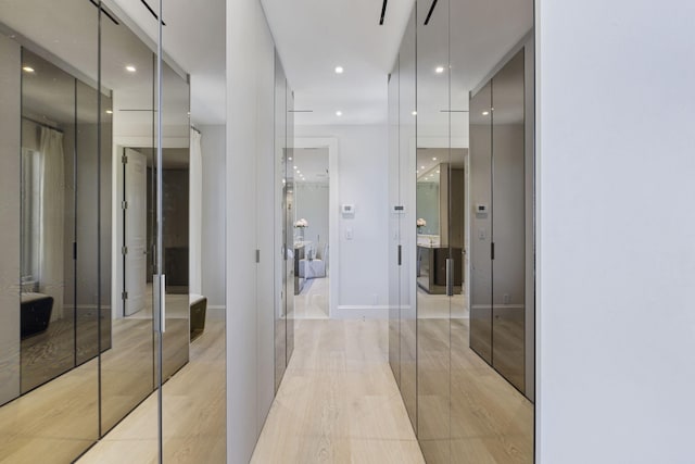 hall featuring recessed lighting, light wood-style flooring, and baseboards