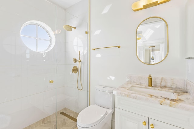 bathroom featuring vanity, a shower stall, and toilet