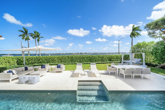 view of pool featuring outdoor lounge area, a fenced in pool, and a patio