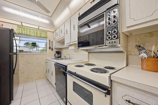 kitchen featuring light tile patterned flooring, sink, black appliances, ceiling fan, and white cabinets