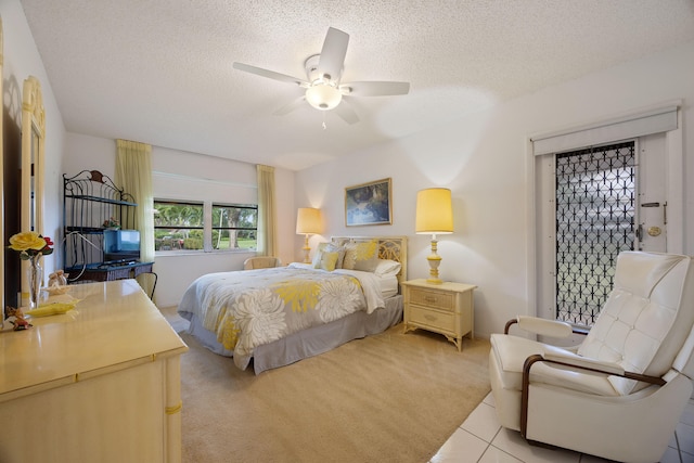 bedroom with a textured ceiling, light carpet, and ceiling fan