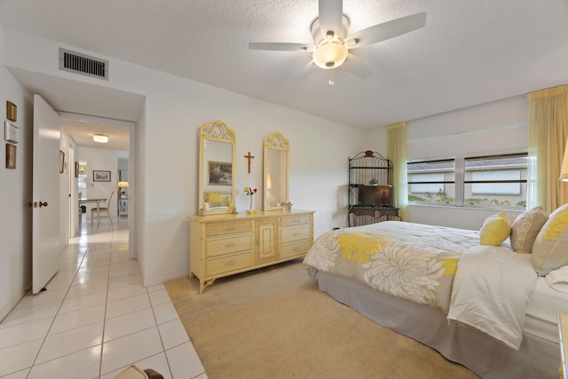 tiled bedroom with a textured ceiling and ceiling fan