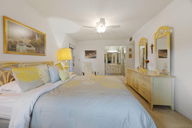 carpeted bedroom featuring a textured ceiling, ceiling fan, and ensuite bath