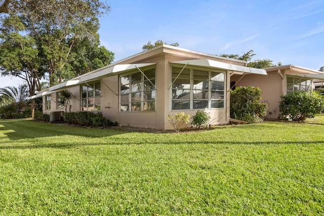 view of home's exterior with central AC unit and a yard