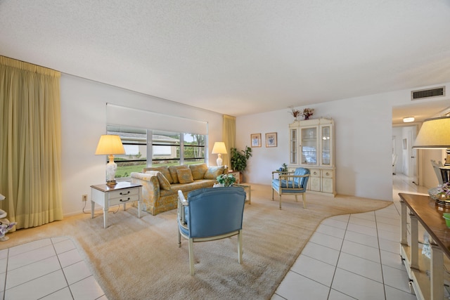 living room with a textured ceiling and light tile patterned floors