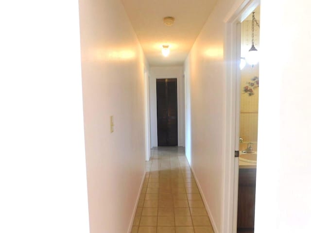 corridor with light tile patterned flooring and sink