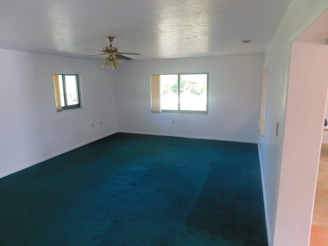 carpeted spare room with plenty of natural light and ceiling fan