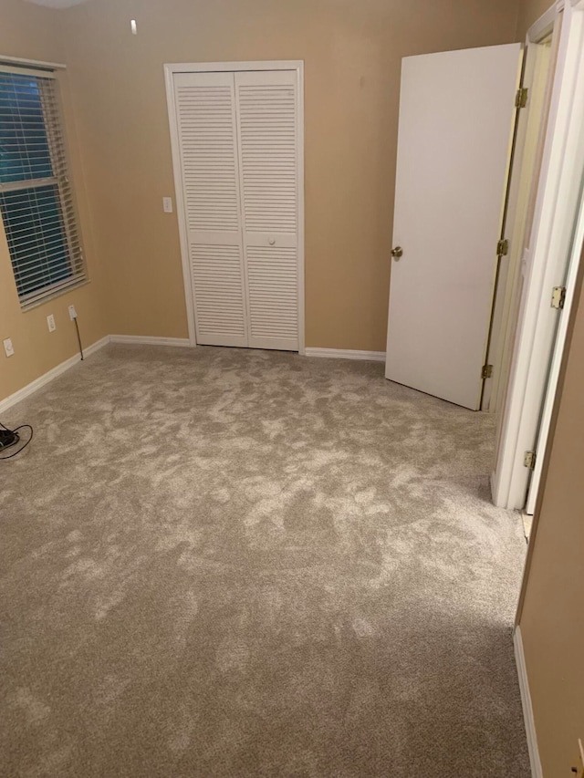 unfurnished bedroom with light carpet and a closet