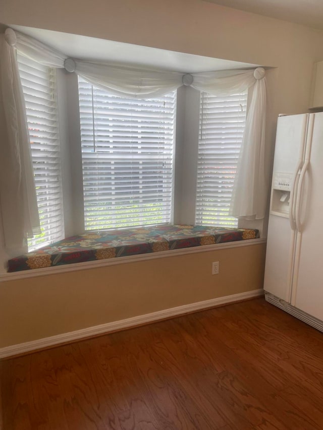 interior space with white refrigerator with ice dispenser and hardwood / wood-style floors