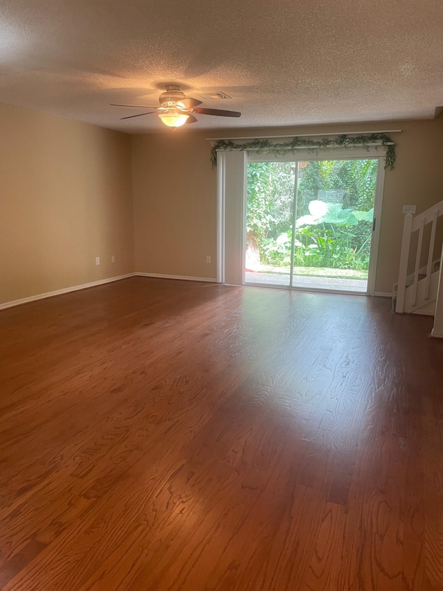 empty room with a textured ceiling, hardwood / wood-style flooring, and ceiling fan