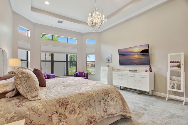 carpeted bedroom featuring a chandelier, a high ceiling, and a tray ceiling