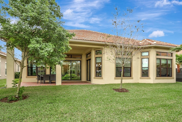 back of house with a yard and a patio