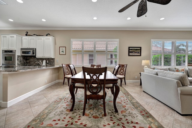 tiled dining space with ornamental molding and ceiling fan