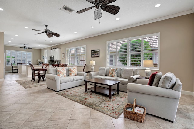 living room featuring ceiling fan, ornamental molding, light tile patterned floors, and a wealth of natural light