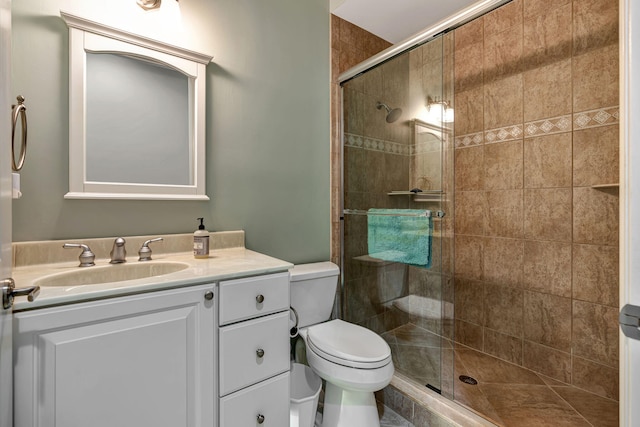 bathroom featuring vanity, a shower with shower door, and toilet