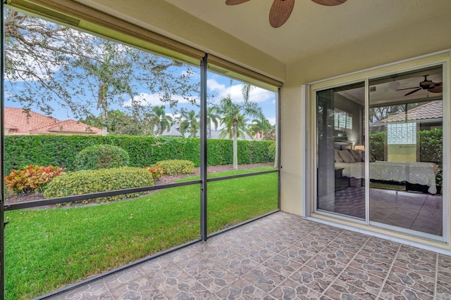 unfurnished sunroom with ceiling fan