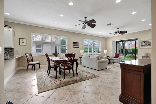 dining area featuring light tile patterned floors, crown molding, and a healthy amount of sunlight