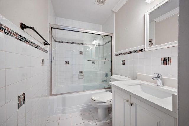 full bathroom with tile walls, shower / bath combination with glass door, toilet, vanity, and tile patterned floors