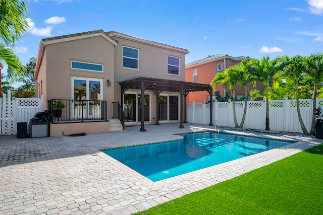 rear view of house featuring a pergola, a patio area, and a fenced in pool