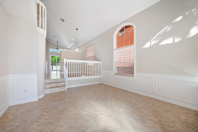 spare room featuring lofted ceiling, ornamental molding, and light tile patterned floors