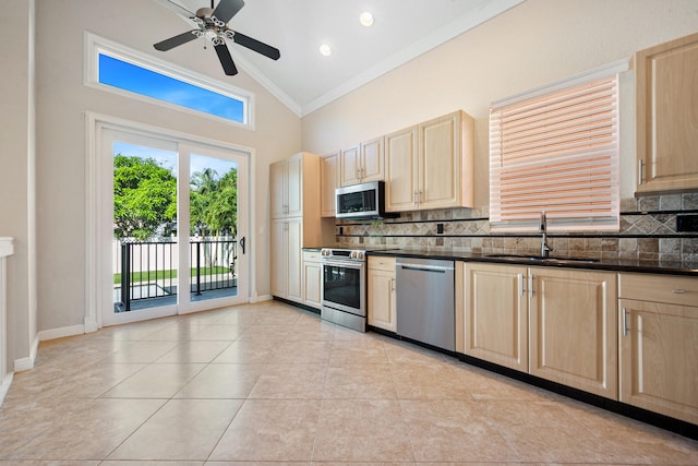 kitchen with ornamental molding, stainless steel appliances, sink, and light tile patterned floors