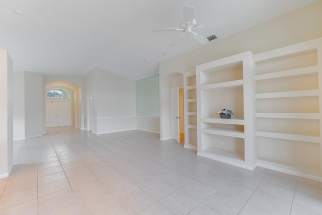 empty room featuring ceiling fan, light tile patterned floors, and built in shelves