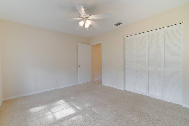 unfurnished bedroom with a closet, carpet flooring, and ceiling fan