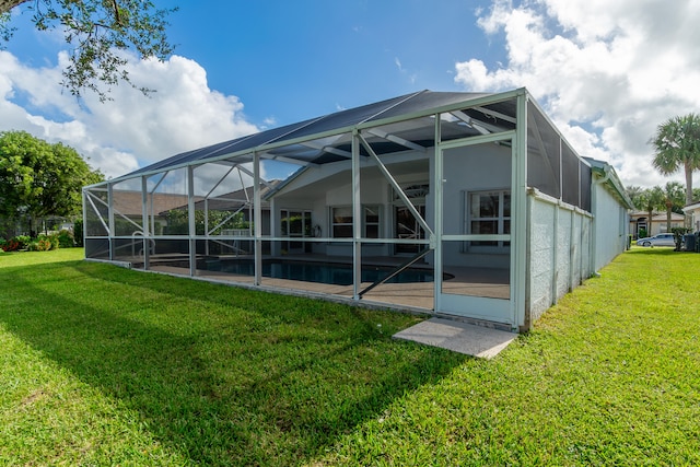 rear view of property with a lanai and a lawn