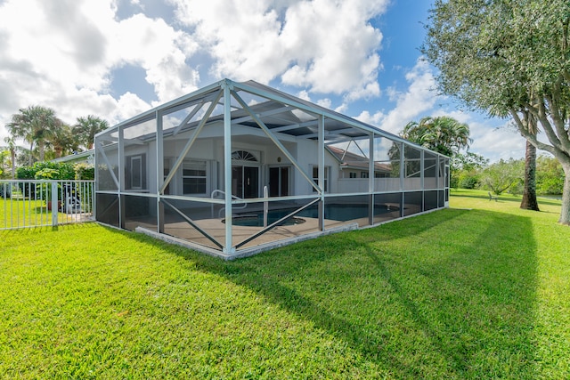 rear view of property with a patio area, a lanai, and a yard