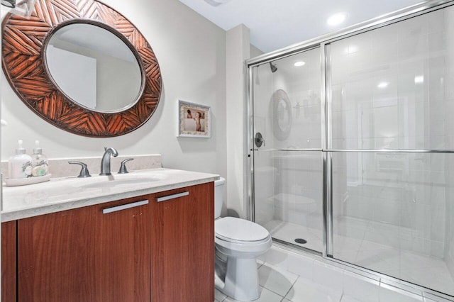 bathroom with vanity, toilet, and a shower with door