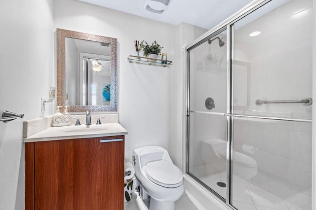 bathroom featuring a shower with door, vanity, and toilet