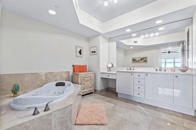 bathroom featuring tiled bath, vanity, and ceiling fan