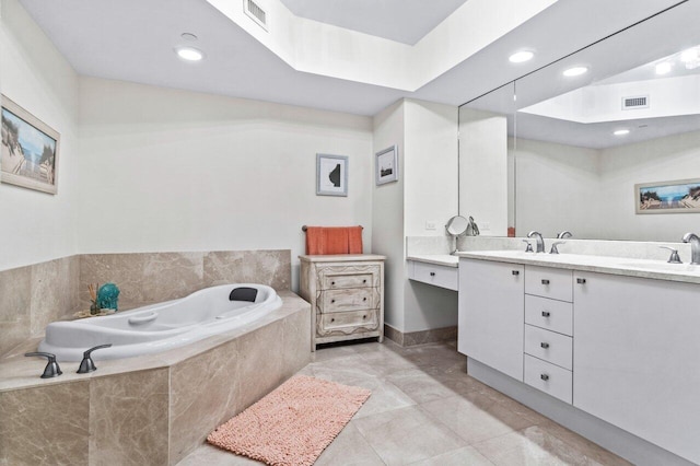 bathroom featuring vanity, tile patterned floors, and tiled tub