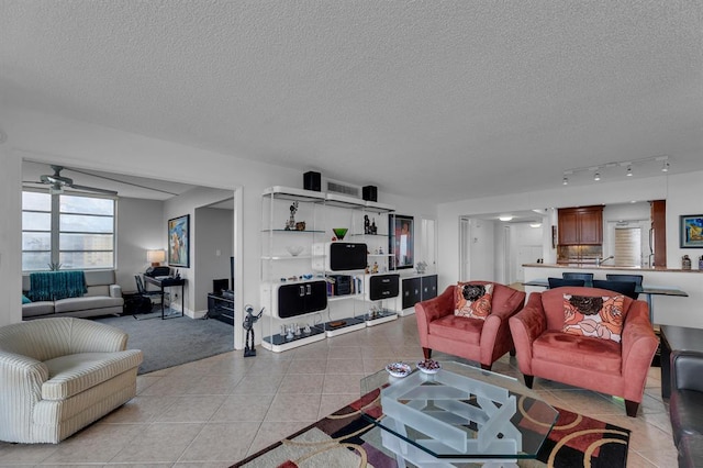 living room featuring ceiling fan, a textured ceiling, and light tile patterned floors