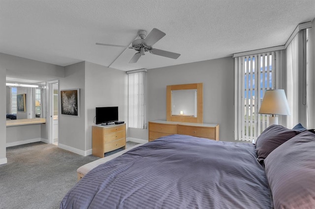 carpeted bedroom featuring ceiling fan and a textured ceiling