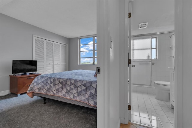 bedroom with light tile patterned floors, multiple windows, and ensuite bath